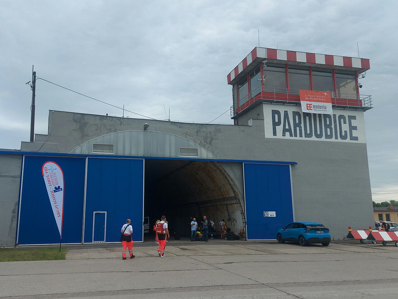 Bývalý vojenský přístřešek pro letadla s nápisem Pardubice a řídicí věží na Letišti Pardubice